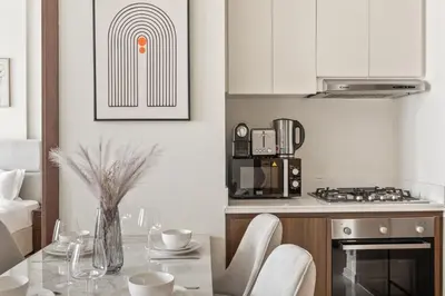 a kitchen with a table with chairs and a microwave at Burj khalifa and Canal views - Luxury Apartments for Rent in Dubai Business Bay in Dubai