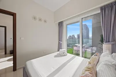 a bedroom with a white bed and a large window at Burj khalifa and Canal views - Luxury Apartments for Rent in Dubai Business Bay in Dubai