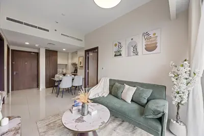 a living room with a green couch and a table at Burj khalifa and Canal views - Luxury Apartments for Rent in Dubai Business Bay in Dubai