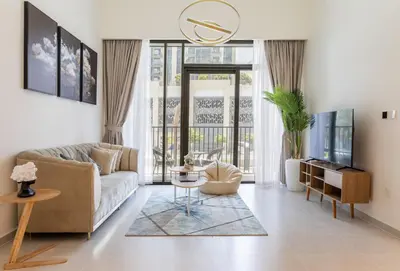a living room with a couch and a tv at Elegant 1 bedroom in Creek Edge in Dubai