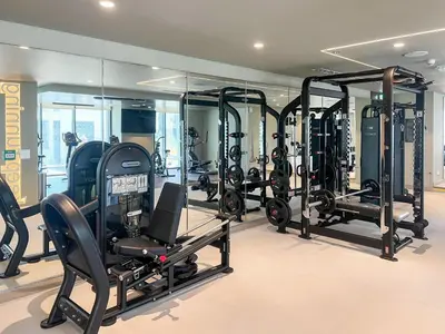a gym with a lot of treadmills and ellipticals at Elegant 1 bedroom in Creek Edge in Dubai