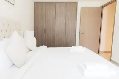 a white bed with white pillows in a bedroom at Elegant 1 bedroom in Creek Edge in Dubai