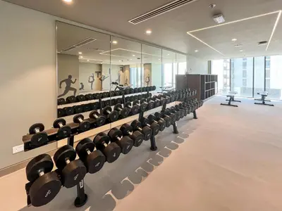 a gym with rows of dumbbells on display at Elegant 1 bedroom in Creek Edge in Dubai