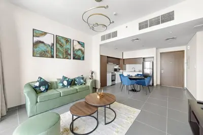 a living room with a green couch and a table at Elegant 1 bedroom in Creek Edge in Dubai