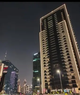 a tall building in a city at night at Studio Chic In Business Bay With Pool and Gym in Dubai