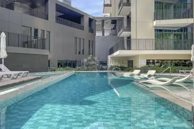 a swimming pool in front of a building at Studio Chic In Business Bay With Pool and Gym in Dubai