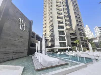 a swimming pool with white chairs and a building at Studio Chic In Business Bay With Pool and Gym in Dubai