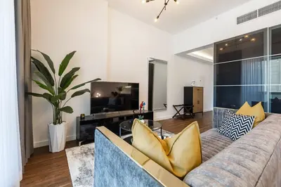 a living room with a couch and a tv at Spacious Luxe Studio Near Metro in Dubai