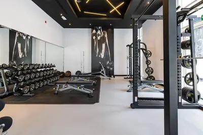 a gym with lots of treadmills and dumbbells at Spacious Luxe Studio Near Metro in Dubai
