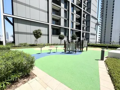 a green lawn in front of a building at Elegant 1 bedroom in Creek Edge in Dubai