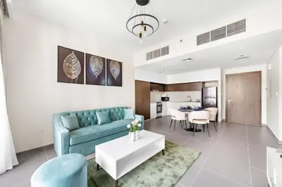 a living room with a blue couch and a table at Elegant 1 bedroom in Creek Edge in Dubai