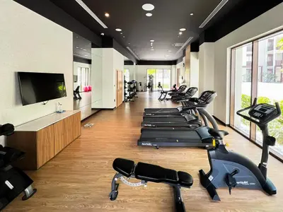 a gym with a row of exercise bikes and a flat screen tv at Elegant at Creek Beach 1 BHK in Dubai