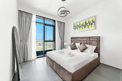 a bedroom with a large bed and a large window at Stylish 1 Bedroom High Floor in Creek Edge in Dubai