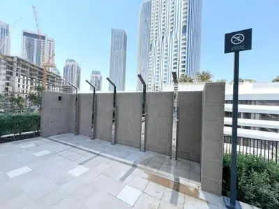 a retaining wall with a fence in a city at Stylish 1 Bedroom High Floor in Creek Edge in Dubai