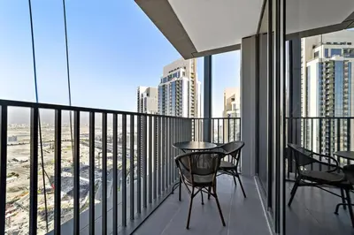 a balcony with a table and chairs on a balcony at Stylish 1 Bedroom High Floor in Creek Edge in Dubai