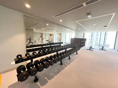 a gym with rows of exercise equipment in a room at Stylish 1 Bedroom High Floor in Creek Edge in Dubai