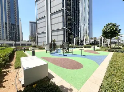 a park with a playground in front of a building at Stylish 1 Bedroom High Floor in Creek Edge in Dubai