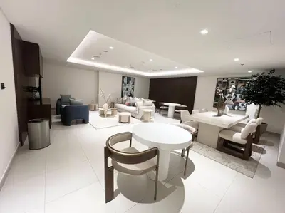 a living room with a table and chairs and a room with tables at Stylish 1 Bedroom High Floor in Creek Edge in Dubai