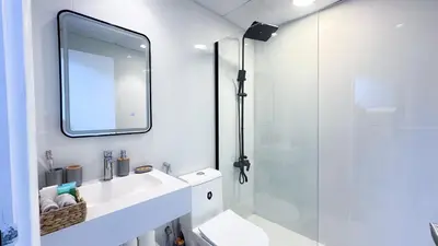 a bathroom with a shower and a sink and a mirror at Dubai Marina - Modern Design Studio Apartment, Marina Diamond 2 in Dubai
