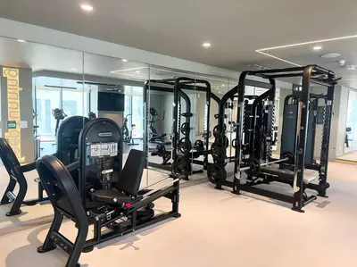 a gym with a lot of treadmills and ellipticals at Stylish 1 Bedroom High Floor in Creek edge in Dubai