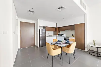 a kitchen and dining room with a table and chairs at Stylish 1 Bedroom High Floor in Creek edge in Dubai