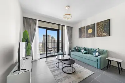 a living room with a blue couch and a table at Stylish 1 Bedroom High Floor in Creek Edge in Dubai
