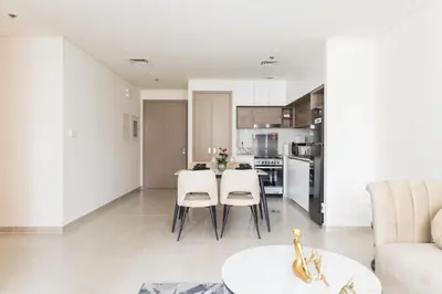 a living room and kitchen with a table and chairs at Elegant 1 bedroom in Creek Edge in Dubai