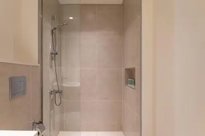 a bathroom with a shower with a glass door at Elegant 1 bedroom in Creek Edge in Dubai