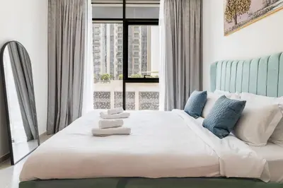 a bedroom with a large white bed with a window at Elegant 1 bedroom in Creek Edge in Dubai