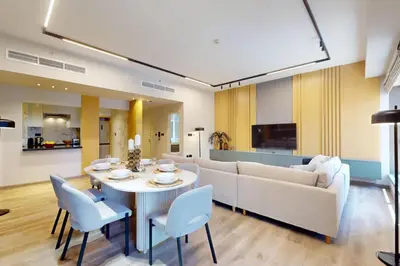 a living room with a couch and a table and chairs at Rimal 1 - Opulant Two Bedroom in Dubai