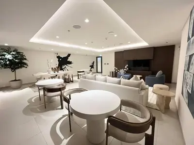 a living room with tables and chairs and a couch at Elegant 1 bedroom in Creek Edge in Dubai