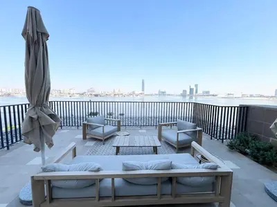 a balcony with two couches and an umbrella at Elegant 1 bedroom in Creek Edge in Dubai
