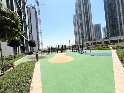 a golf course in the middle of a city with tall buildings at Elegant 1 bedroom in Creek Edge in Dubai