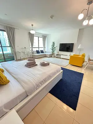 a large bedroom with a large bed and a living room at Prime Spacious Studio with Vibrant Vibes in JBR By SWEET HOMES in Dubai