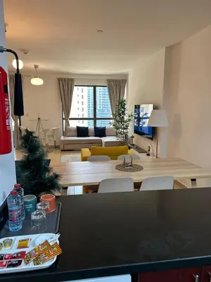 a living room with a table and a living room with a couch at Prime Spacious Studio with Vibrant Vibes in JBR By SWEET HOMES in Dubai