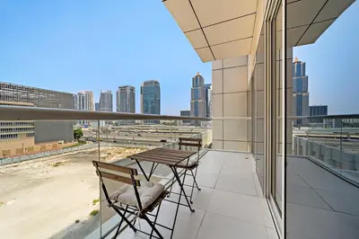 a balcony with two chairs and a table on a building at Stonetree - Brand New 1 BR in Prime Location in Dubai