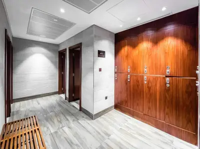 a room with wooden lockers and a wooden bench at Chic 1-Bed Near Marina Promenade - 5 min to Tram in Dubai