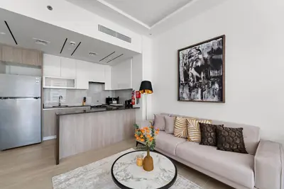 a living room with a couch and a kitchen at Big Studio - WOW facilities in Dubai