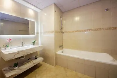 a bathroom with a sink and a tub and a mirror at Stunning Marina view apartment In Marina sail tower by Truebleu vacation homes in Dubai