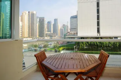 a table and chairs on a balcony with a view of a city at Stunning Marina view apartment In Marina sail tower by Truebleu vacation homes in Dubai