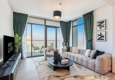 a living room with a couch and a view of the ocean at 2-BR Getaway at Palace Residences, Dubai Creek in Dubai
