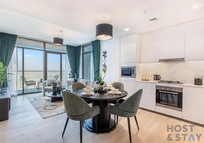 a kitchen and living room with a table and chairs at 2-BR Getaway at Palace Residences, Dubai Creek in Dubai