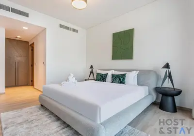 a bedroom with a large white bed and a couch at 2-BR Getaway at Palace Residences, Dubai Creek in Dubai
