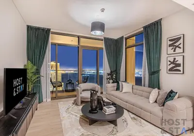 a living room with a couch and a tv at 2-BR Getaway at Palace Residences, Dubai Creek in Dubai