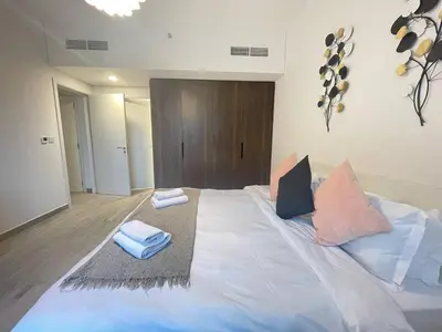 a large bed with pillows on it in a room at Luxe & Comfy Madinat Jumeirah - Apartment with Scenic Views - Pool Managed by SunnyHomes in Dubai