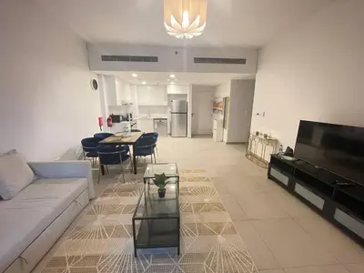 a living room with a couch and a table and a kitchen at Luxe & Comfy Madinat Jumeirah - Apartment with Scenic Views - Pool Managed by SunnyHomes in Dubai