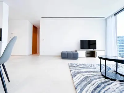 a white living room with a table and a rug at Stylish One-Bedroom Getaway in Business Bay in Dubai