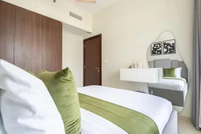 a bedroom with two beds with green and white at Frank Porter - Vera Residences in Dubai