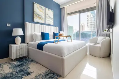 a bedroom with a white bed and a blue wall at Frank Porter - Vera Residences in Dubai