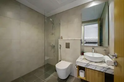 a bathroom with a toilet and a sink and a shower at Stylish Studio with Great Views High Floor in Dubai